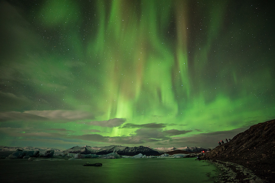 'Land of Ice' workshop group shooting Aurora, January 2014. Image courtesy of Lorenzo Riva, used with the artist's permission. The lowermost light is me - I was standing partially inside the lagoon's water.