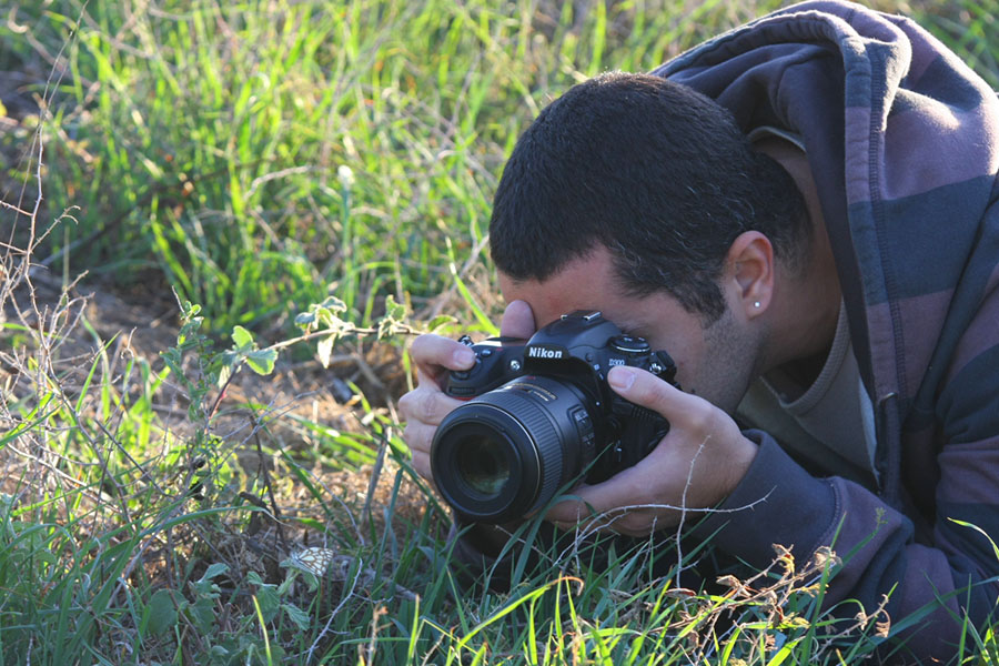 Photographer Ori Saar shoots a butterfly from eye-level. Ori knows that the butterfly's low position compels him to lie on the damp earth if he wants the right angle of view.