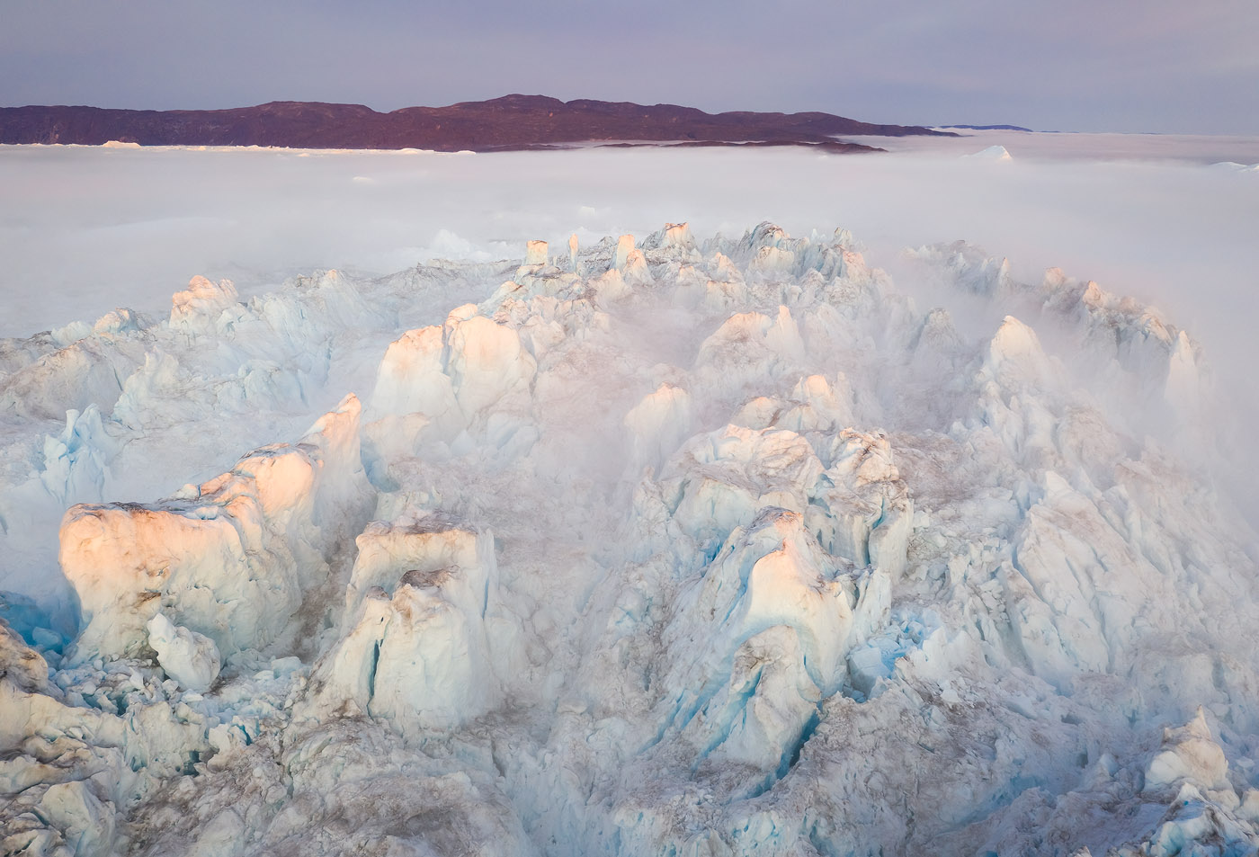 This light on the top of a huge iceberg was disappearing and reappearing with the horizon clouds obscuring the sun to the north west. With the drone, I had the choice of when exactly to fly to optimize my photography and get the best light.