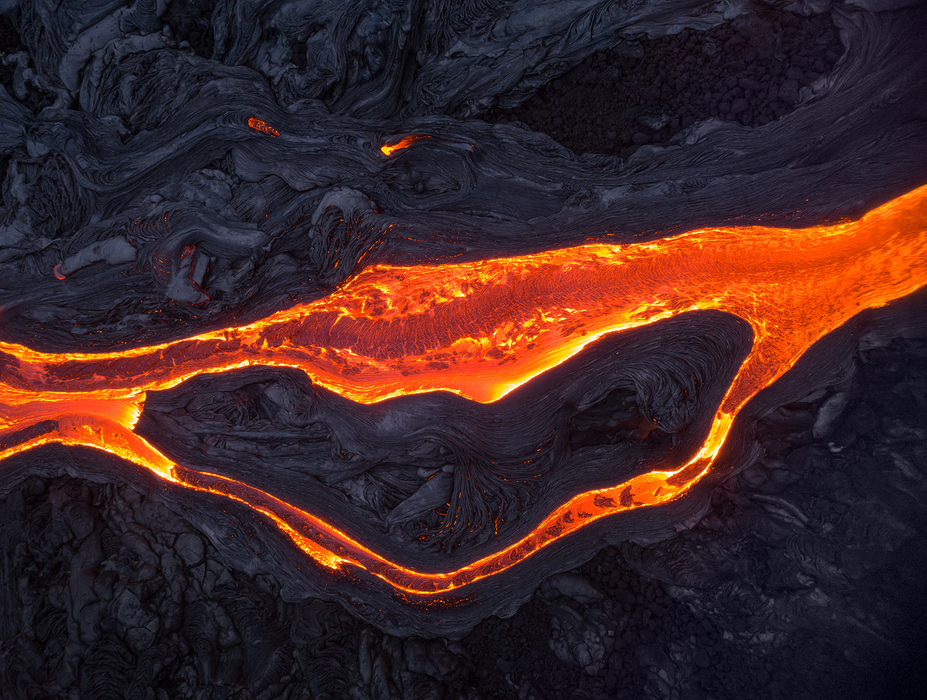 I carried three Phantom batteries for 8 km on solidified lava to shoot these surface flows in Kilauea Volcano. The batteries alone weighed almost 1.5 kilograms, not to mention the drone itself, my DSLR gear, tripod and 2 liters of water. While worth it, the backpack was very heavy and the hike wasn't much fun. Even so, I would in retrospect bring two more batteries, to be able to use them more sparingly on a rare shoot such as this one. </br>DJI Phantom 4 Pro, 1/15 sec, F6.3, ISO 400. Taken outside of Volcanoes NP, Island of Hawaii.