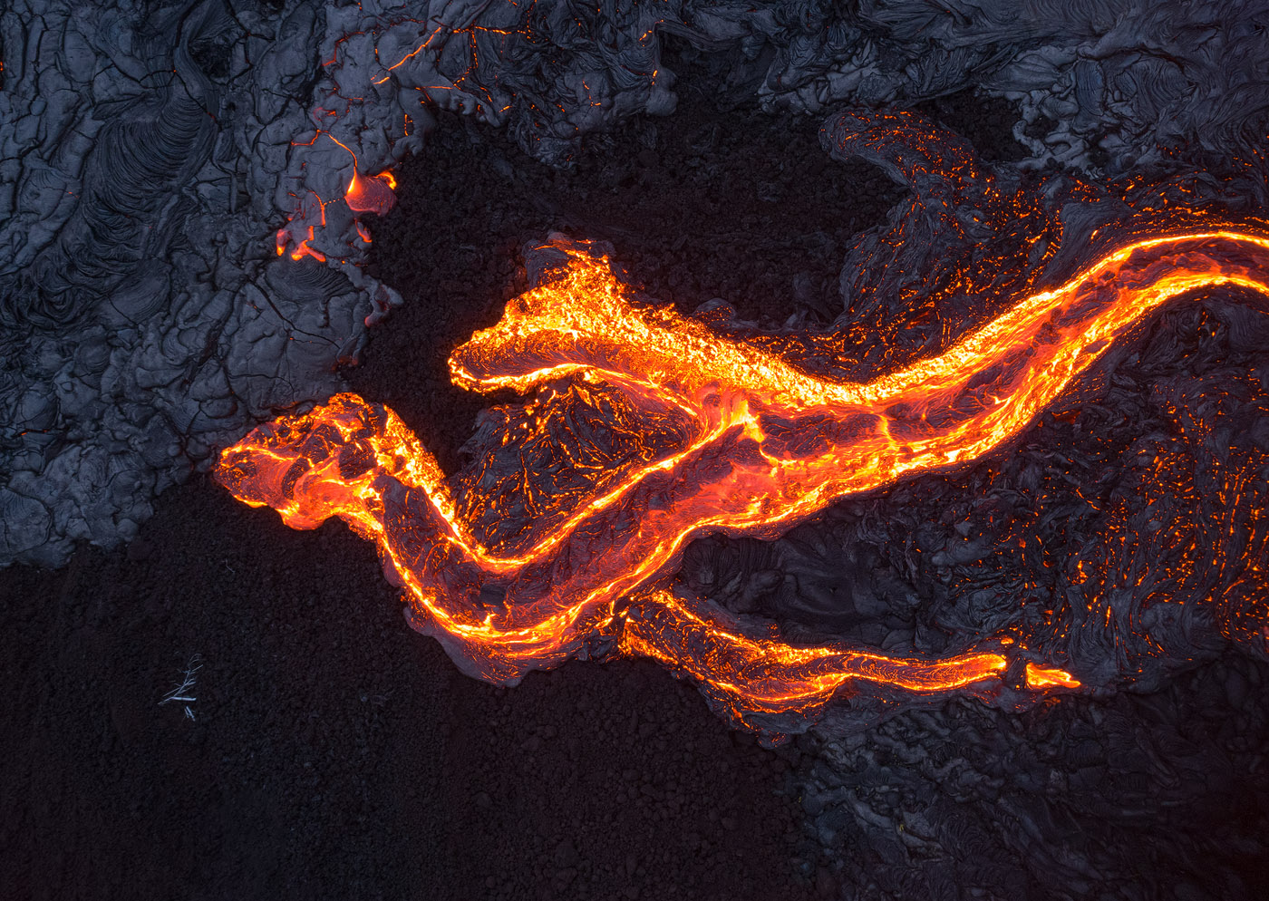 Lava flows in the shape of a double-headed dragon. During this shoot I flew my drone so close to the lava that the camera was molten (!). Needless to say, I wouldn't get this close myself. </br>DJI Phantom 4 Pro, 1/8 sec, F6.3, ISO 400. Taken outside of Volcanoes NP, Island of Hawaii.