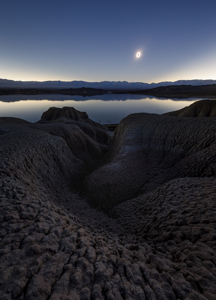 A total solar eclipse in a shootable place is a rare occurrence, but it's even rarer to have it so low in the sky as to allow a near-far landscape composition. The eclipse totally changed the image compared to only having the badlands in the shot. <br>Canon EOS 5D Mark IV, Canon 11–24mm f/4, 1.6 sec, f/13, ISO 800 (focus stack). <br>Lago Cuesta del Viento, San Juan province, Argentina