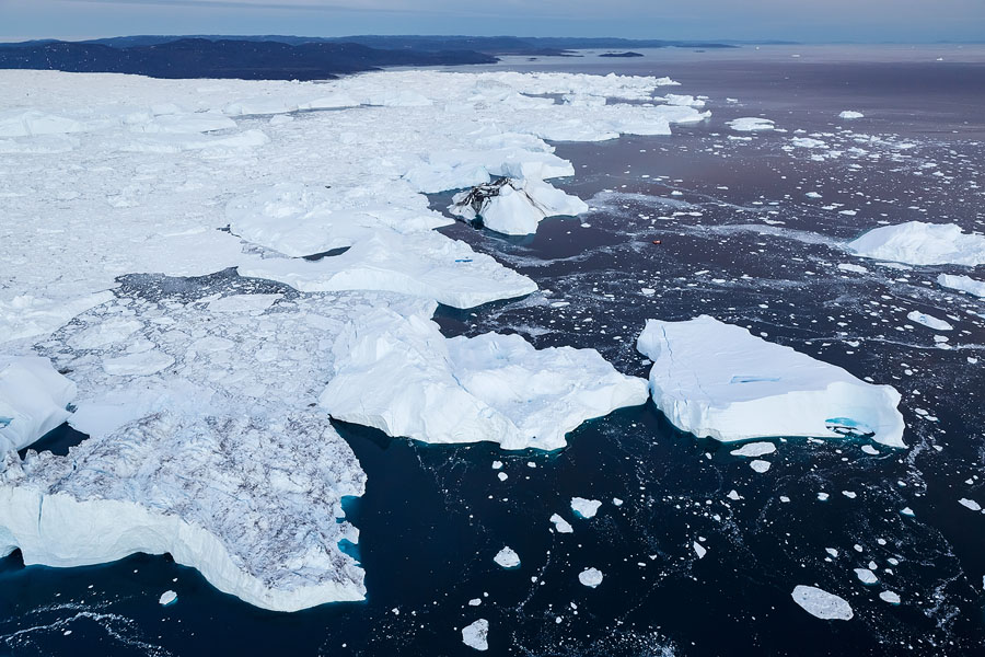 Huge icebergs finally released from Kangia Fjord after floating there for years. Can you spot the (fairly large) boat? Disko Bay, Greenland.