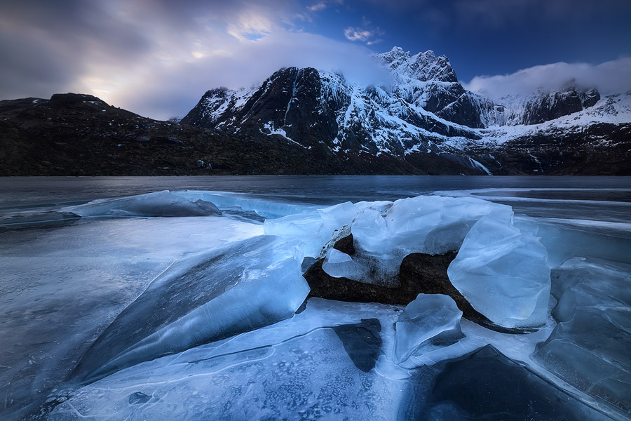 Beautiful blue ice, sculpted into curious formations by the immense pressure of the frozen surface against the rocks on the bottom of the lake. The characteristic mountains and magical light make this one of my favorite shots from this trip.