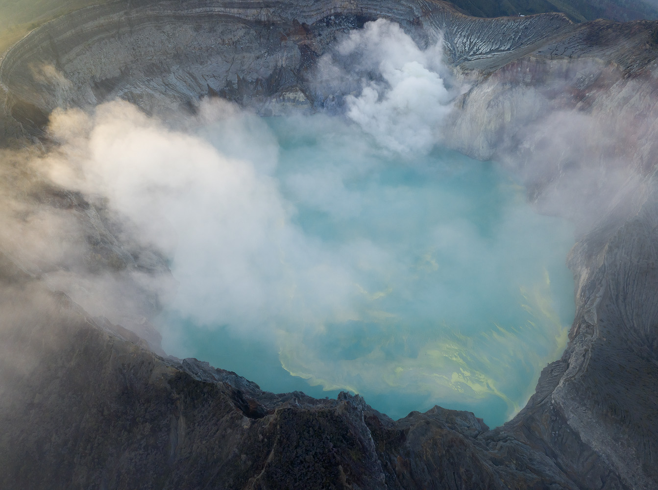 An aerial look into the crater lake. Note the yellow sulfur deposits